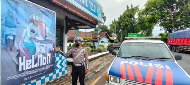 
					Petugas saat menunjukan foto pengguna jalan yang benar