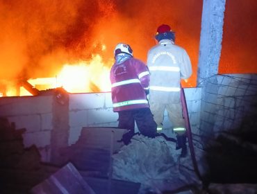Petugas saat berusaha memadamkan api yang berkobar didalam gudang