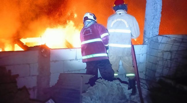 Petugas saat berusaha memadamkan api yang berkobar didalam gudang