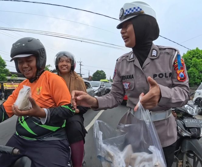 
					Polwan Satlantas Polres Pasuruan saat membagikan makanan kepada pengendara dijalan