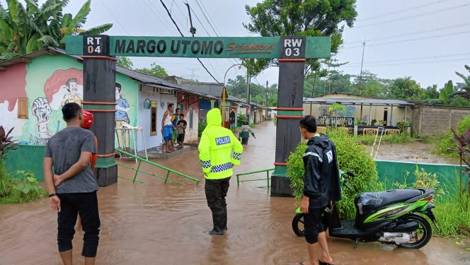 
					Petugas saat meninjau lokasi banjir