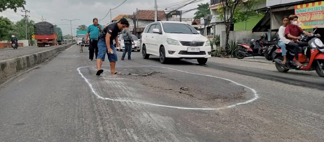 
					Relawan dari komunitas ILKP Korcam Gempol saat memberi tanda jalan yang berlobang