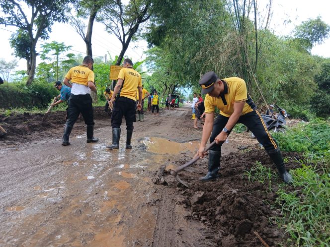 
					Anggota Polsek Winongan dibantu warga sekitar saat melakukan pembersihan lumpur pasca banjir