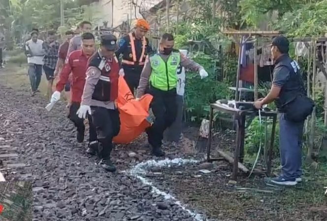 
					Petugas saat mengevakuasi jenazah korban