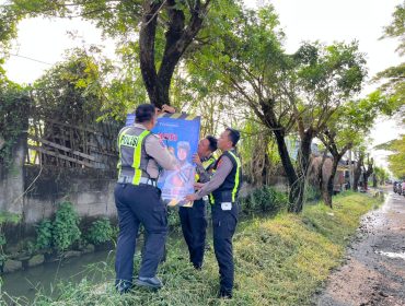 Petugas dari Satlantas Polres Pasuruan saat memasang banner