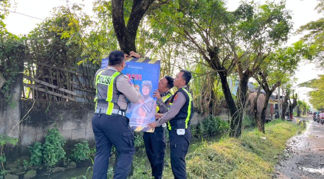 Petugas dari Satlantas Polres Pasuruan saat memasang banner