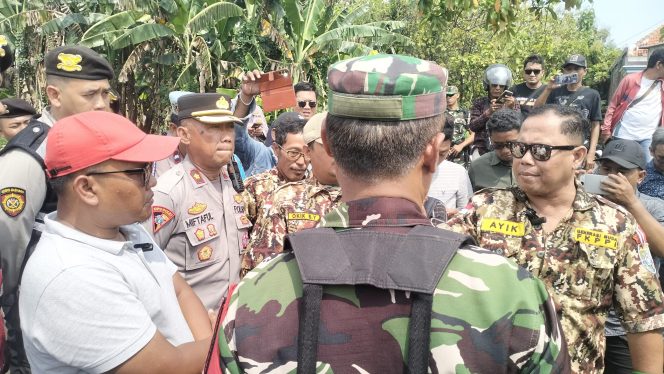 
					Ayik Suhaya, S.H., (kanan), saat berargumen dengan Salman (topi merah) di lokasi Proyek KMP Kelurahan Sebani, Kecamatan Gadingrejo, Kota Pasuruan